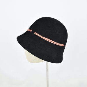 Black fur felt with narrow coral colored ribbon in a classic cloche style. Side view.