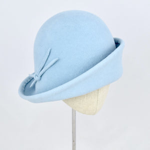 Baby blue velour fur felt with an asymmetrical flip. 3/4 front view.