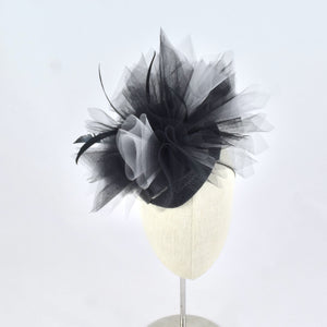 Black sinamay tear drop percher with black and grey tulle, black sculpted feathers, and vintage leather buckle.  Front view.