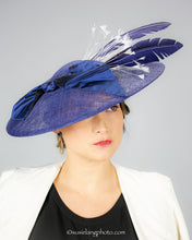 Load image into Gallery viewer, Royal blue sinamay saucer with silk bow and hand dyed feathers on a bandeau base. Front view
