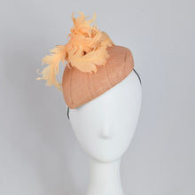 Load image into Gallery viewer, A peach colored fascinator hat made with vintage straw and curled feathers, displayed on a mannequin head.
