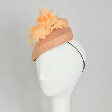 Load image into Gallery viewer, A peach colored fascinator hat made with vintage straw and curled feathers, displayed on a mannequin head.
