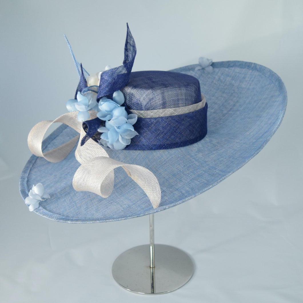 Beautiful wide sweeping brim in two tones of sinamay, with sinamay swirls and hand made flowers. 