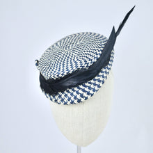 Load image into Gallery viewer, Short brimmed perching cap made in navy and white buntal straw with feathers.  Front view.
