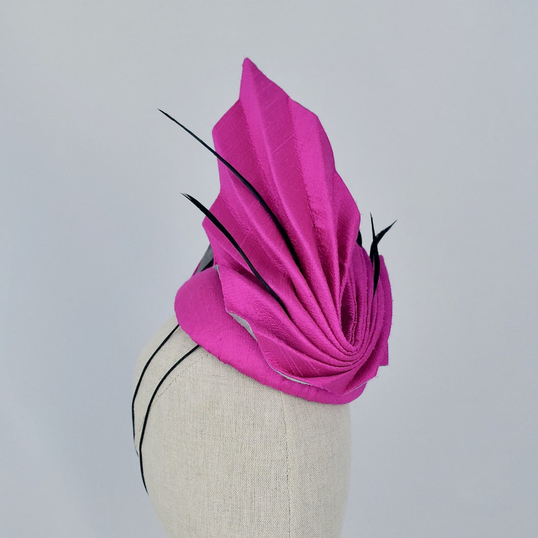 Pleated vibrant pink silk on silver sinamay with black biot feathers.