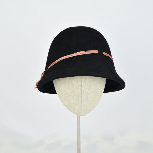 Black fur felt with narrow coral colored ribbon in a classic cloche style. Front view.