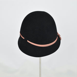 Black fur felt with narrow coral colored ribbon in a classic cloche style. Back view.