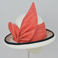 Load image into Gallery viewer, Winter white velour felt bowler with a pleated trim of coral colored silk and black grosgrain ribbon. 3/4 front view.
