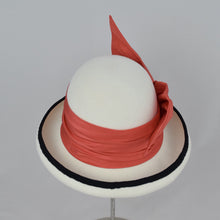 Load image into Gallery viewer, Winter white velour felt bowler with a pleated trim of coral colored silk and black grosgrain ribbon. Back view.
