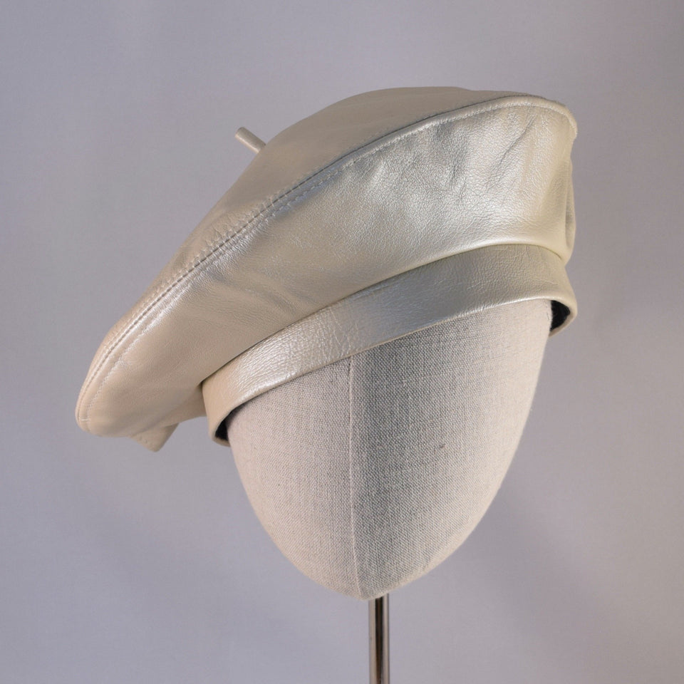 Classic beret in oyster colored leather.  Front view.