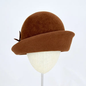 Chocolate brown velour fur felt with an asymmetrical flip. Front view.