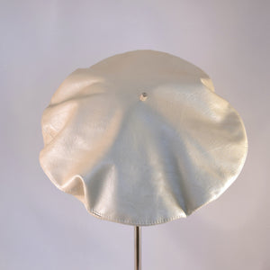 Classic beret in oyster colored leather.  Back view.