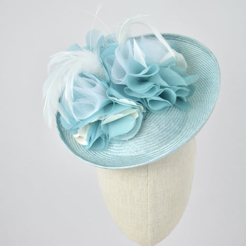 Saucer hat in ice blue parisisal with silk and feather trim.  Front view.