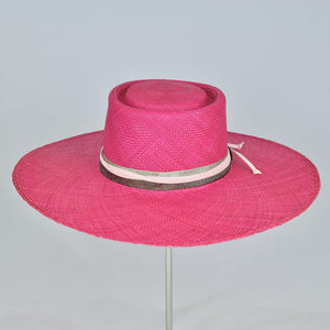Shocking pink panama straw with a telescope crown and wide, flat brim. Back view.